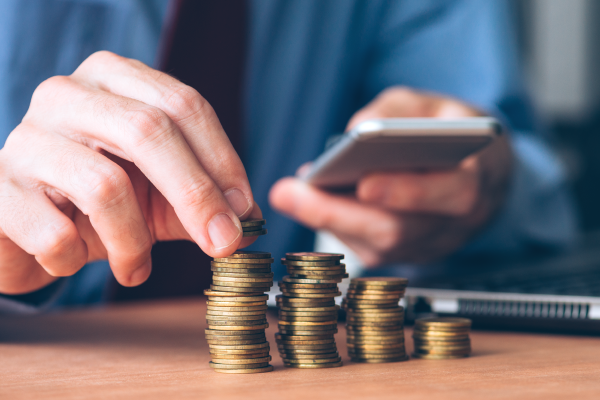 businessman-using-smartphone-with-stacked-coins-1