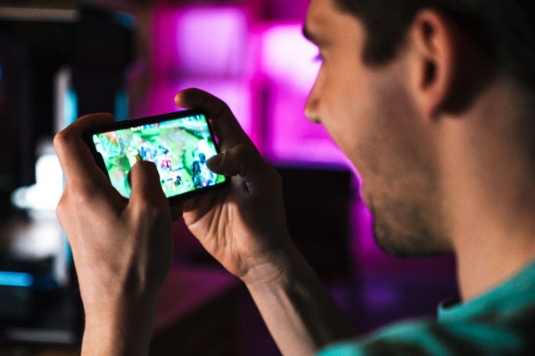 closeup-of-smiling-man-playing-video-game-on