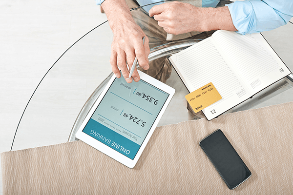 hands-of-retired-man-with-digital-tablet-and-bank-1-1